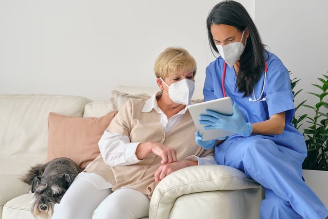 Doctor sharing tablet with mature patient during examination in