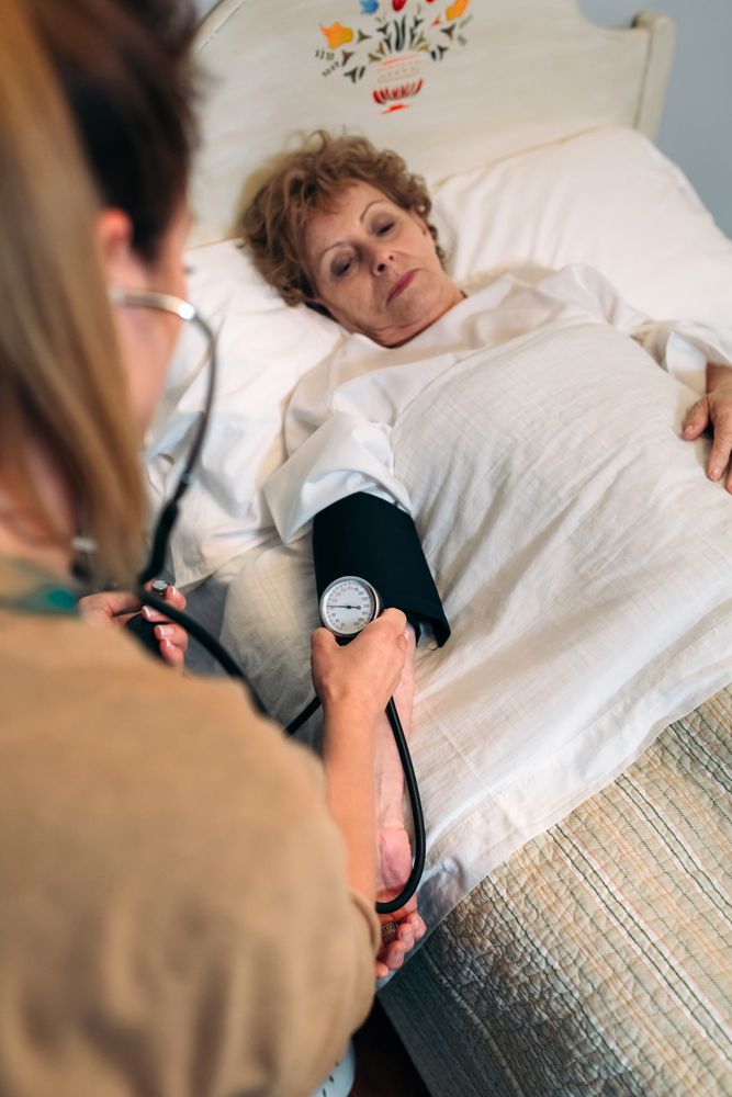 Caregiver checking blood pressure to a woman