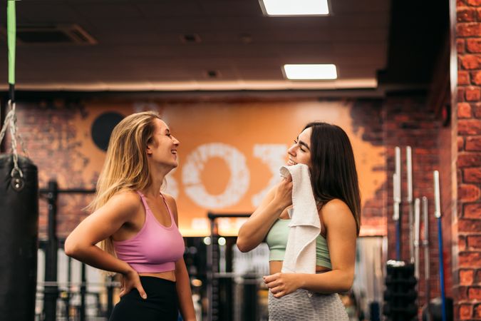 two young women talking in the gym while resting