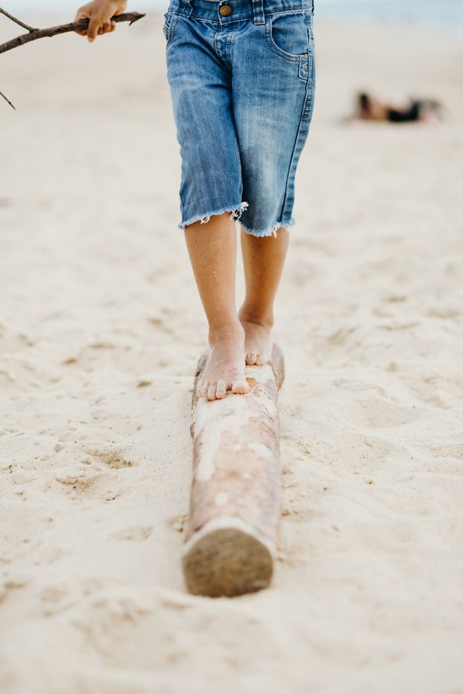 Anonymous Black kid walking on log
