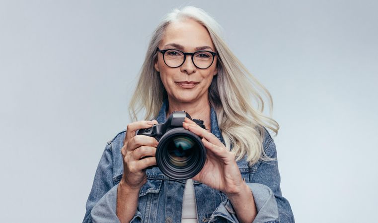 Portrait of  woman standing with dslr camera