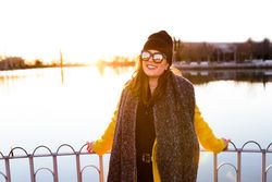 Charming woman in casual wear on shore of lake