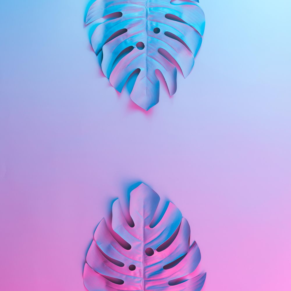 Tropical leaves in vibrant bold gradient blue and pink holographic neon colors