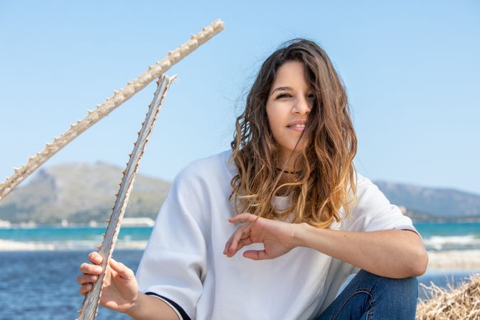 Young woman sitting near dried plants