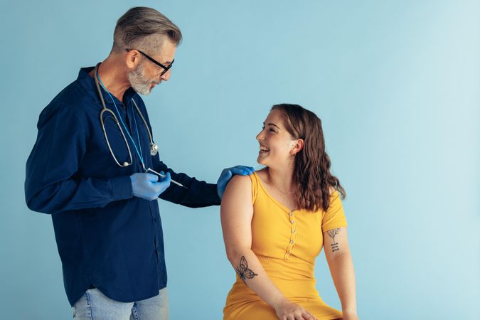 Woman getting vaccine from a male general practitioner