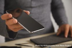 Close up of man holding smart phone in repair shop 5pBKyb