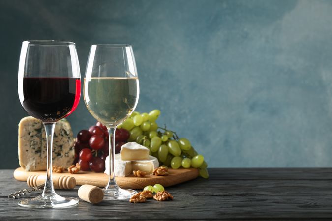 Grape, cheese, corkscrew, glasses with wine, on wooden background, copy space