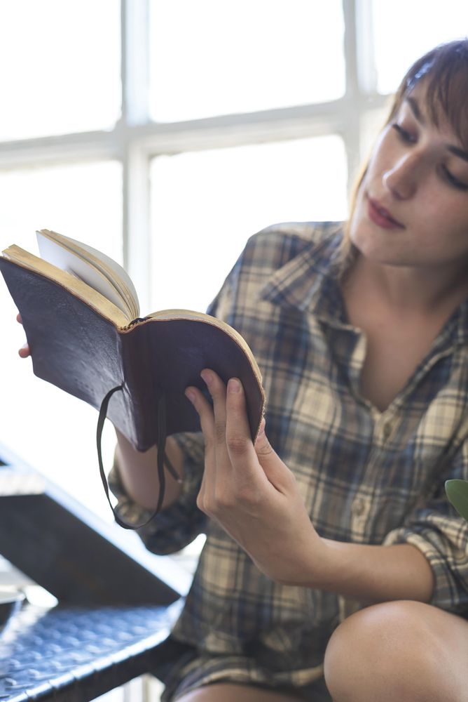 Curious woman reading book on stairs