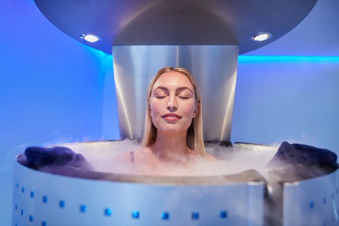 Blonde woman in cryotherapy chamber with eyes closed