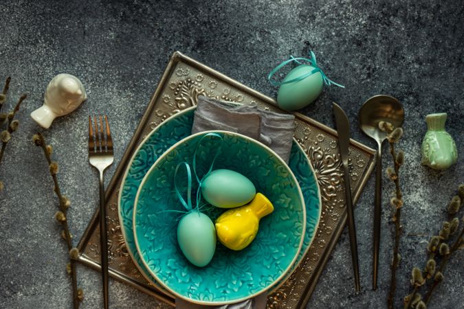 Teal bowl of egg ornaments for table setting