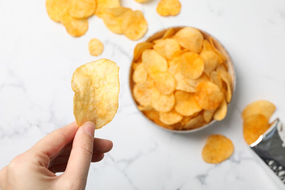 Potato chips in a bowl on a light background
