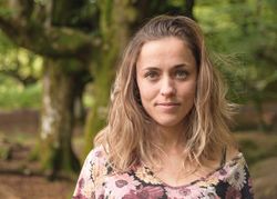 Portrait of young woman against forest