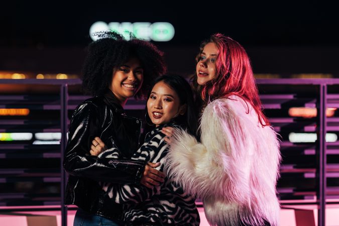 Multi-ethnic group of glamorous women on terrace at night