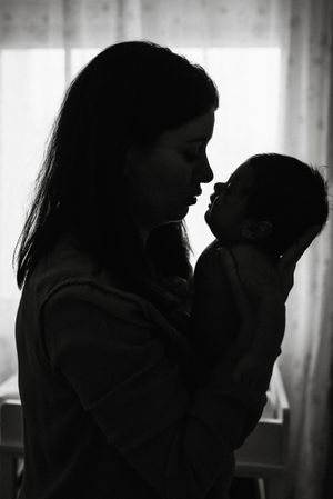 Mom holding newborn on hands at home