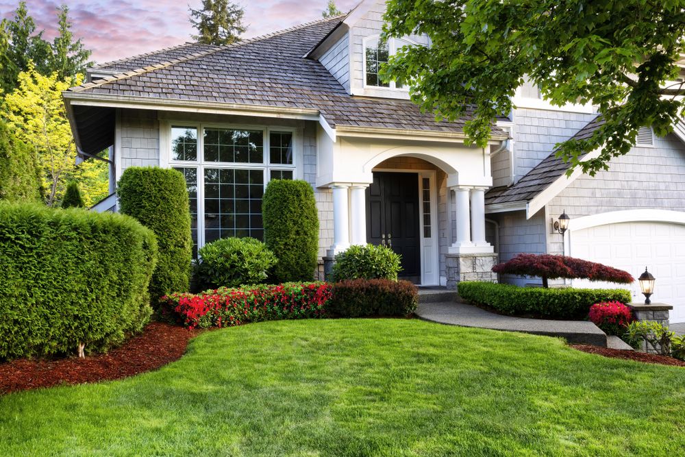 Front view of home with plush grass and flowerbeds