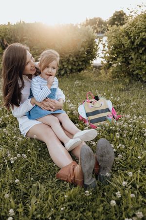 Mother and daughter sitting on lawn