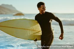 Happy young man with surfboard on beach 4NmZm5