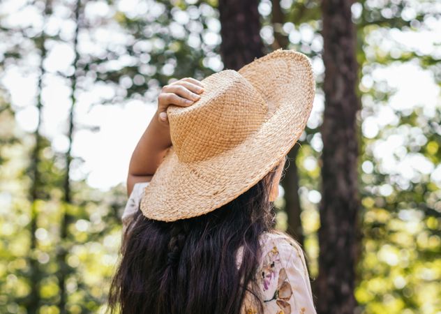 Woman with straw hat in the forest