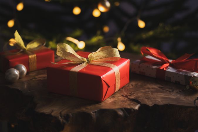 Christmas gifts on wooden table near tree