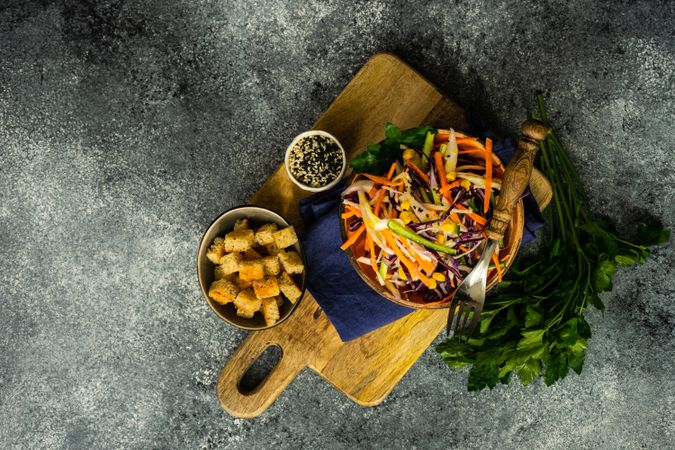 Top view of fresh salad with vegetables in bowl on stone background with copy space