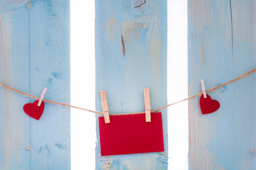 Blank red paper note and hearts on a string