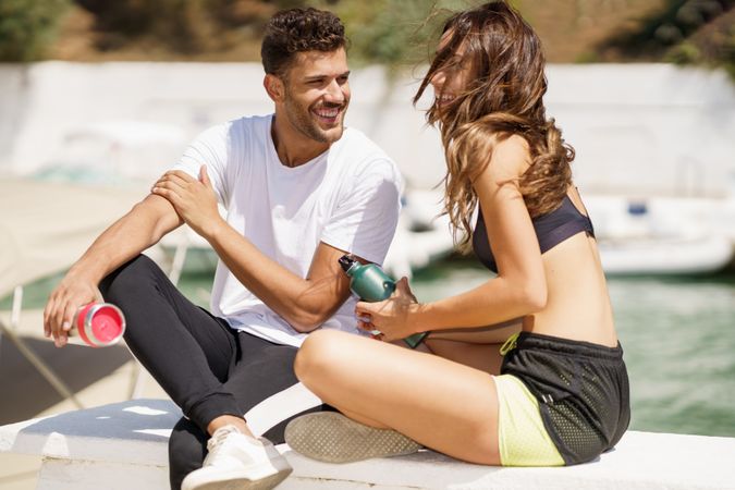 Couple talking on pier on sunny day