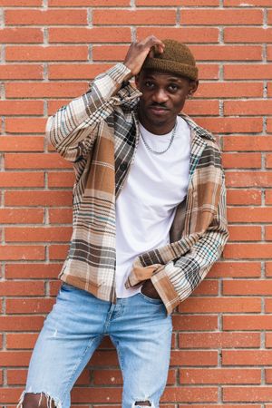Stylish Black man against brick wall