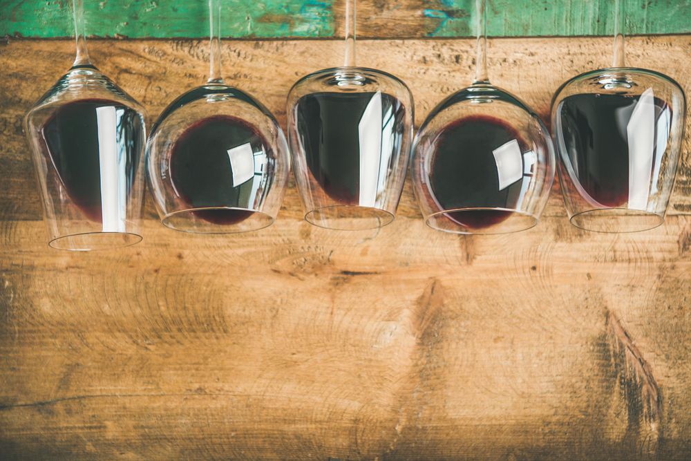 Glasses of red wine glasses laying on wooden background, with copy space
