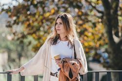 thoughtful woman leaning on handhold and looking along