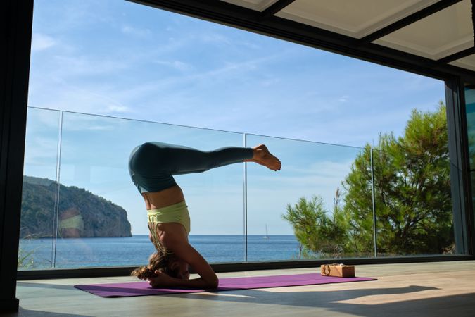 Fit woman doing Supported Headstand Pike