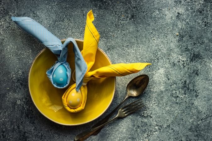 Colorful egg decorations on bright yellow plate