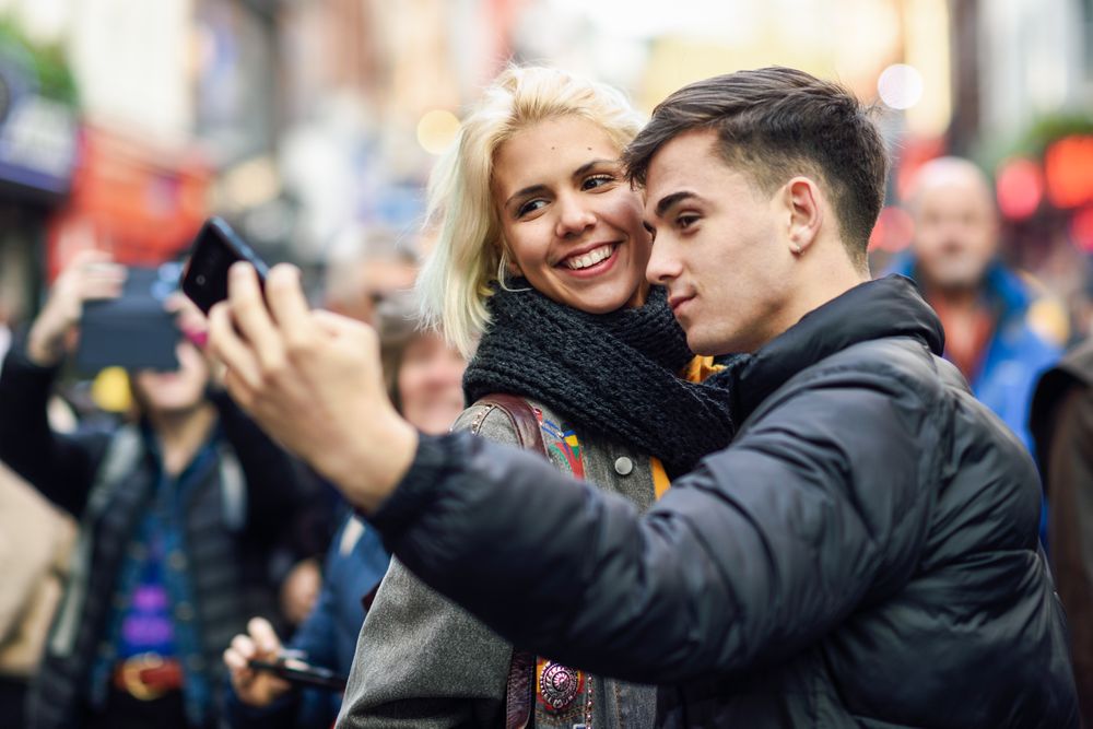 Male and female taking selfie in UK street