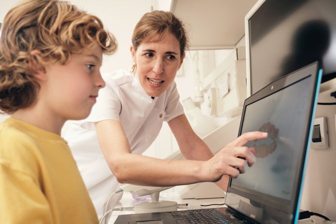 Dentists showing teeth scan to kid
