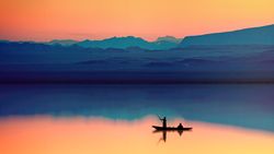 Silhouette of person riding on boat on lake