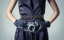 Model holding vintage camera in chic dress