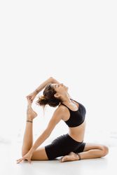 Sportive woman performing yoga pose in room