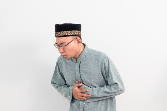 Asian Muslim man feeling touching stomach, hungry during fasting in Ramadan