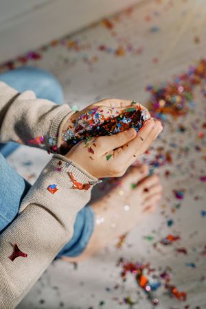 Boy collecting confetti from floor at party