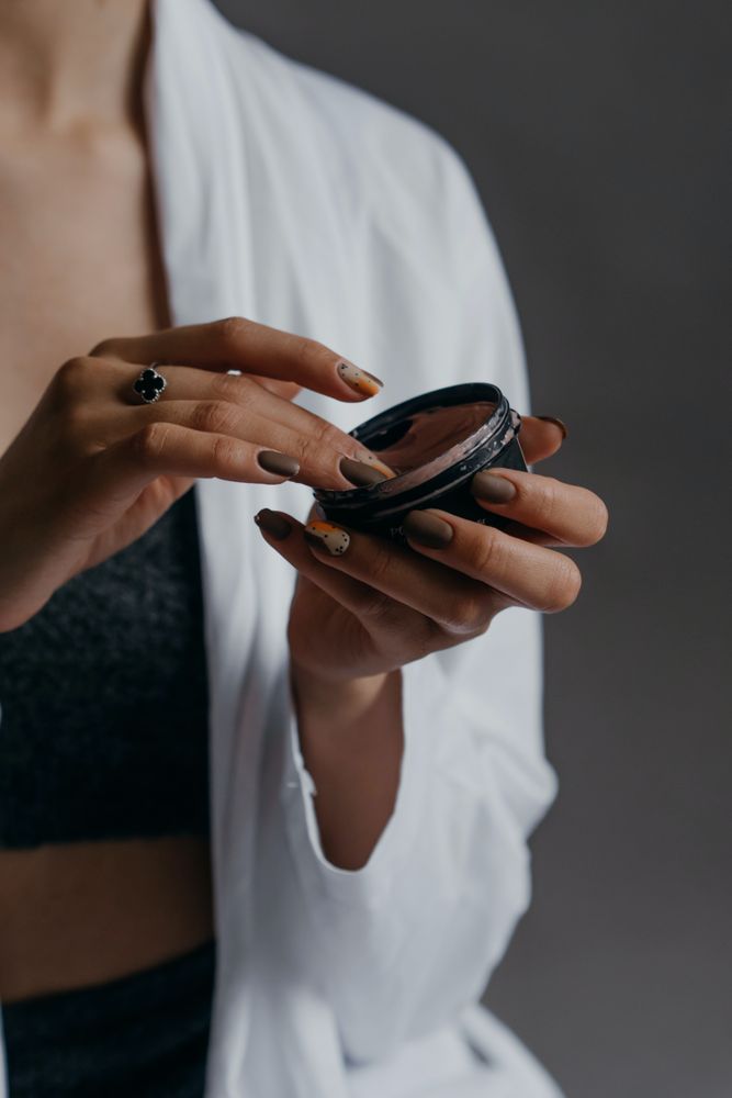 Cropped image of woman holding brown concealer make-up
