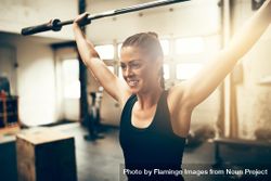 Healthy woman holding barbell atop her head 5nLqnb