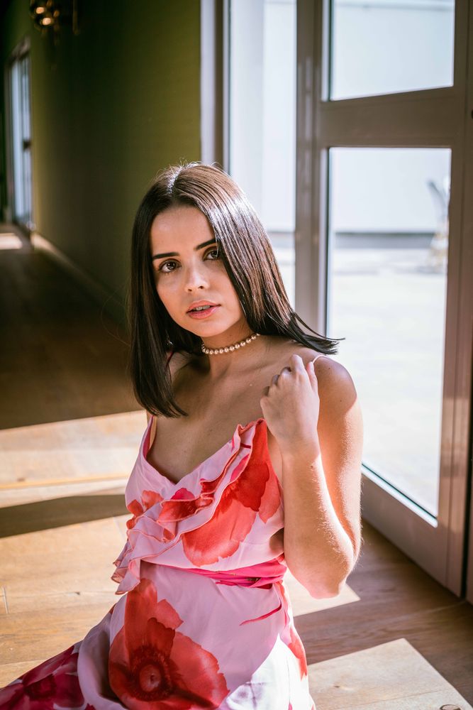 Stylish young woman in dress posing in room