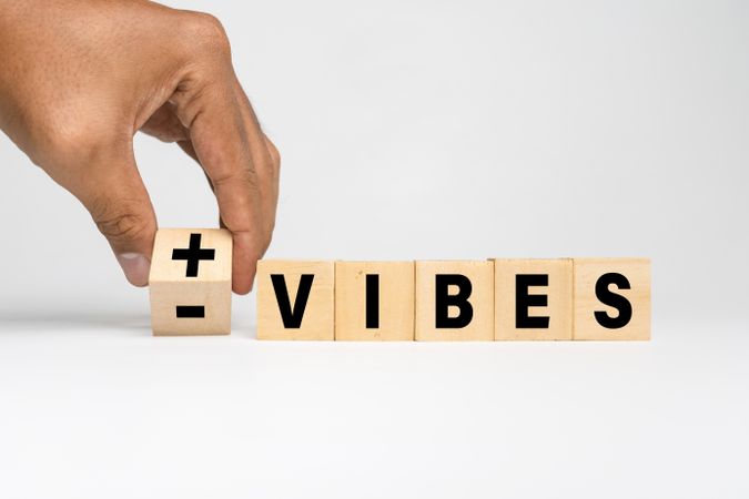 male hand flip wooden blocks with positive and negative vibes