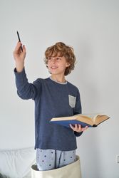 Content kid with pencil and book at home