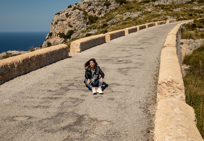 Woman sitting on stony path in countryside