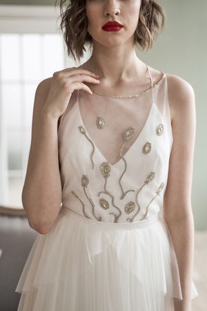 Young woman with red lips in elegant white dress looking at camera