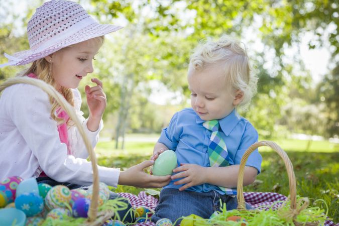 Cute Young Brother and Sister Enjoying Their Easter Eggs Outside