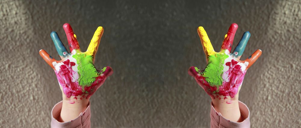 Cropped shot of childs hands with palms painted bright colors