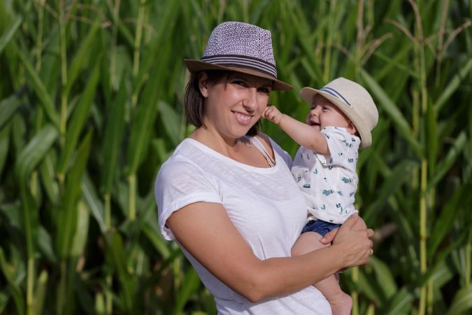 Adorable mother and child on hand enjoying and laughing in field