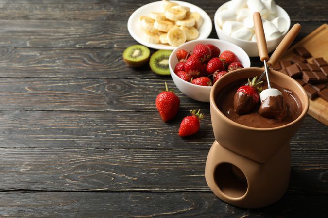 Composition with ingredients for chocolate fondue on wooden background. Cooking fondue