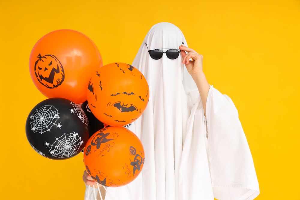 Concept of Halloween, Ghost with Halloween balloons on yellow background